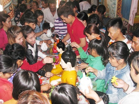 Người dân cùng tắm cho Phật bằng các cành hoa.