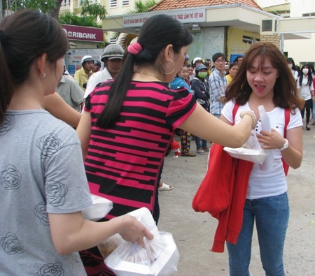 Đón thí sinh ngoài cổng trường thi để phát cơm miễn phí.