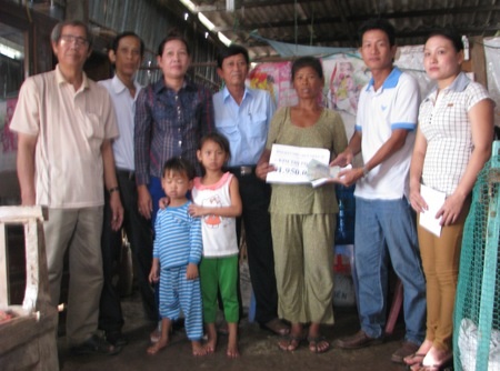 PV Dân trí và đại diện ban ngành địa phương cùng trao tiền bạn đọc đến bà cháu bà Kim Thị Phượng.