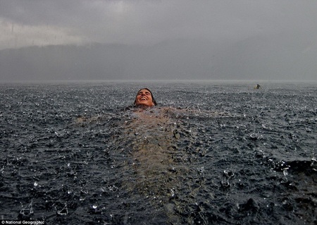 Một cô gái bơi dưới mưa tại Lago Caburgua, miền nam Chile. Đây là bức ảnh mang tên