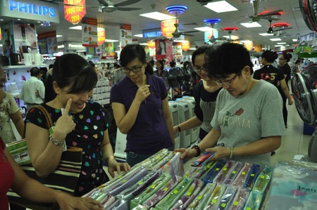 Nhiều người tranh thủ vừa xếp hàng vừa xem, chọn lựa những sản phẩm mình cần mua qua phần quảng cáo