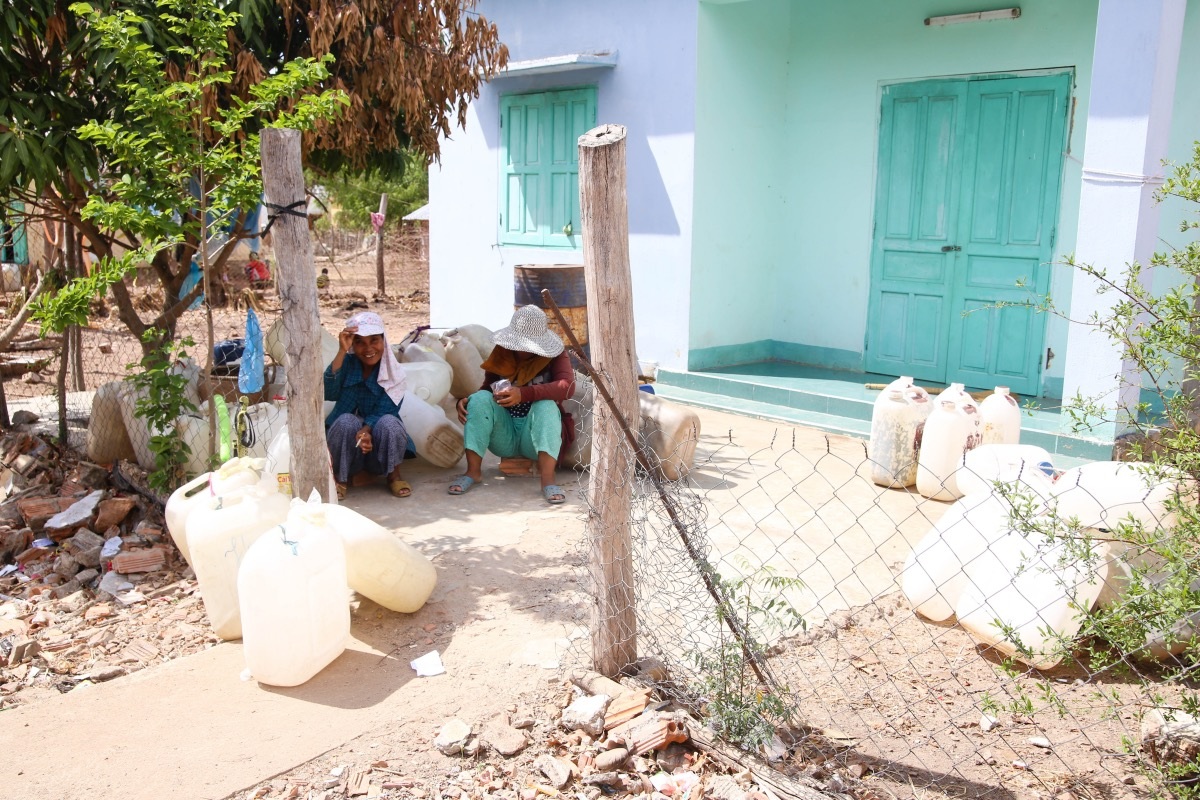 Người dân ngồi chờ lấy nước.