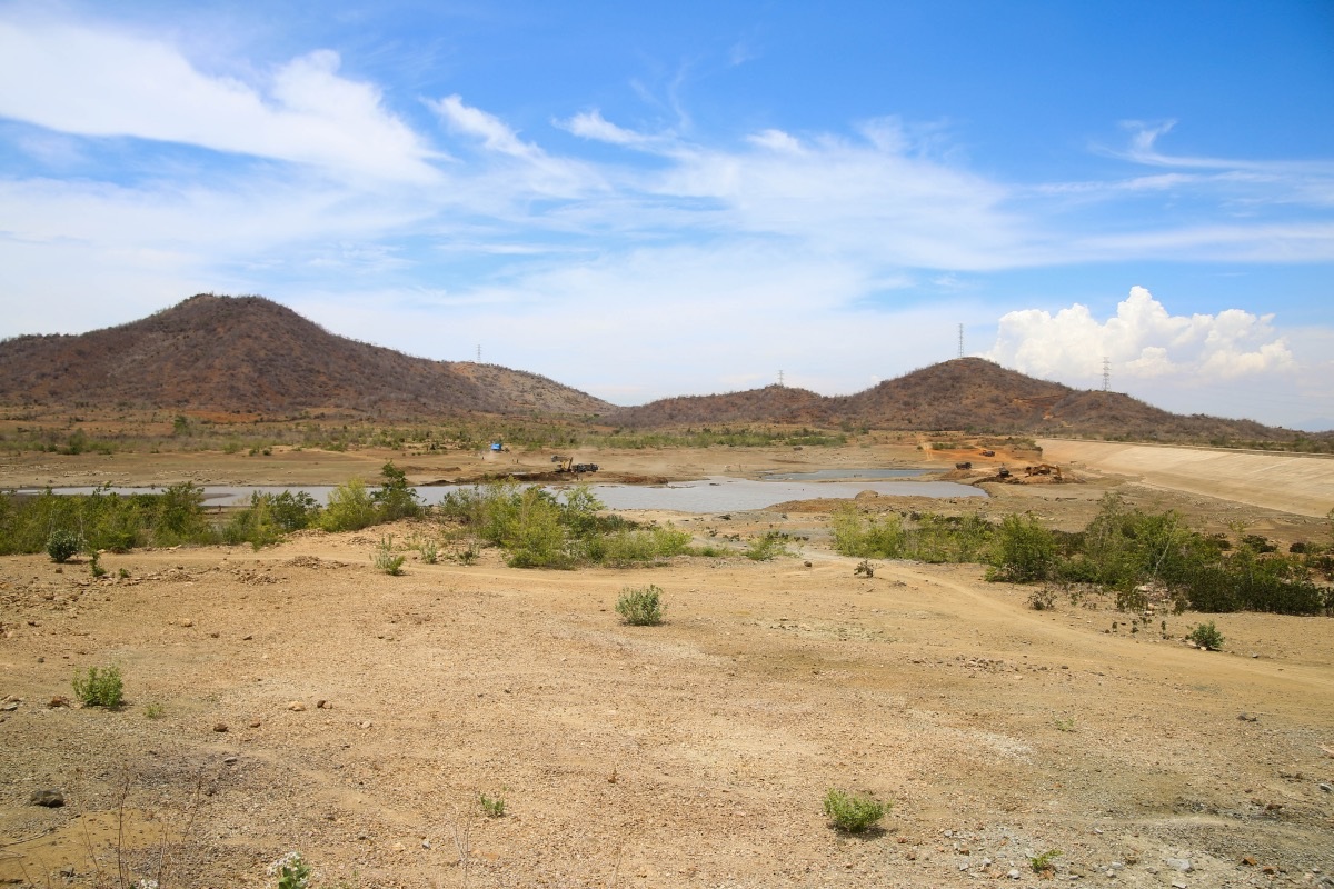 Lòng hồ không còn nước, chỉ còn lác đác vài vũng nước. Xe múc liên tục nạo véc để tìm nguồn nước