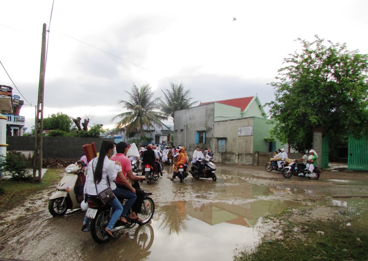 Dù đường lầy lội do trận mưa tối hôm trước nhưng dòng người đổ về nghĩa
trang càng lúc càng đông.