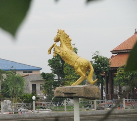 Có một hồ nước rộng lớn, với bức tượng ngựa màu vàng nổi bật giữa hồ.