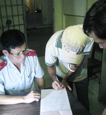 Tài xế xe ký vào biên bản vi phạm khi vận chuyển tôm giống không rõ xuất xứ giấy tờ.