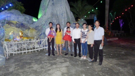 Một gia đình công giáo chụp ảnh kỷ niệm mùa giáng sinh với vị Linh mục nhà thờ.