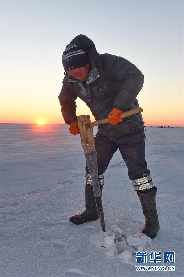 Người ngư dân khoan lỗ trên mặt băng