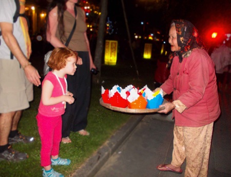 Bà lão bán đèn hoa đăng bên cạnh em bé nước ngoài  (ảnh: N.T)