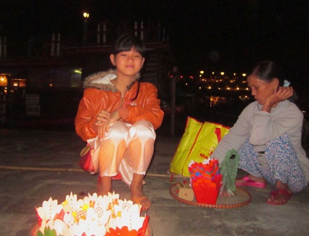Bé gái cùng mẹ bán hoa đăng dọc sông Hoài (ảnh: N.T)