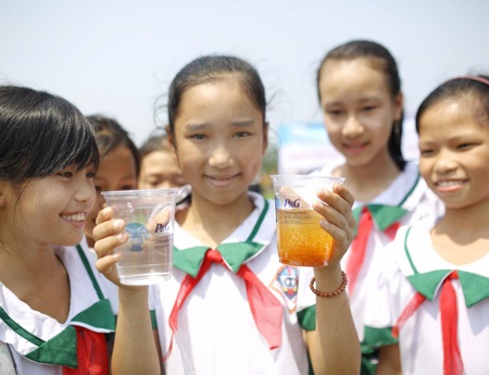 Các em học sinh Quảng Trị vui mừng thưởng thức ly nước được lọc sạch nhờ túi bột lọc nước.