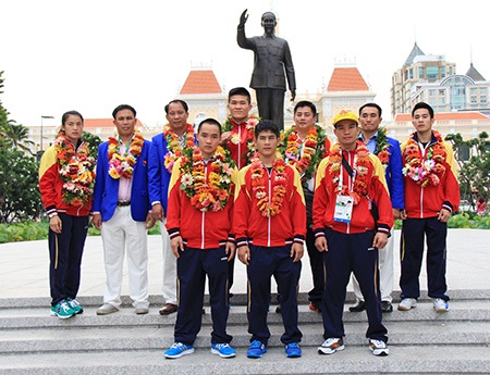 Các VĐV, HLV sau khi về nước, dâng hoa và chụp hình lưu niệm trước tượng đài Bác, ở TPHCM