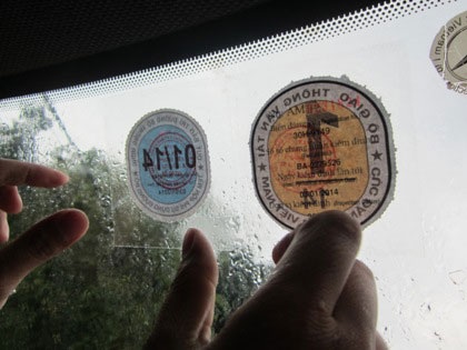 Tem chứng nhận đóng phí bảo trì đường bộ được dán trên kính xe cùng tem kiểm định