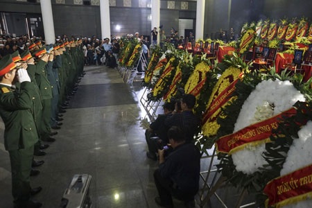 Cán bộ chiến sĩ QĐND Việt Nam nghiêng mình bên linh cữu các chiến sĩ (ảnh: Hữu Nghị)