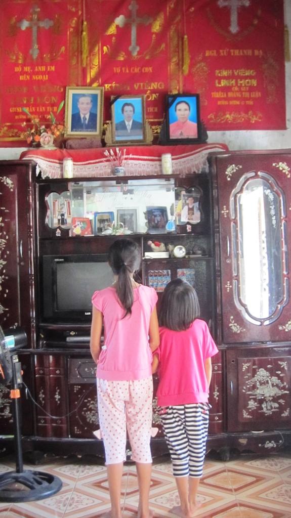 Nỗi nhớ thương của những đứa bé thơ dại trong căn nhà vắng bóng bố mẹ. Hai em Hường và Hồng ngước nhìn di ảnh bố mẹ