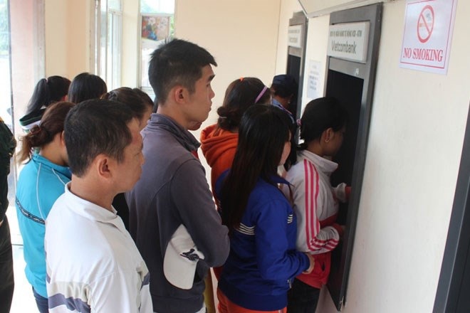 Tín dụng đen “hút máu” công nhân: “Cắm” thẻ dễ, nhưng “nhổ”... khó - 1 Công nhân xếp hàng rút tiền tại quầy thẻ ATM ở KCN Biên Hòa 1.