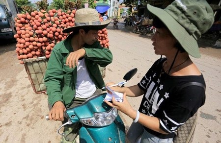 Vải đỏ đường Bắc Giang, nông dân lại bị ép giá - 6 Thương lái Trung Quốc ra đường đưa tờ phiếu báo giá, người bán đồng ý thì chở vào điểm thu mua vải