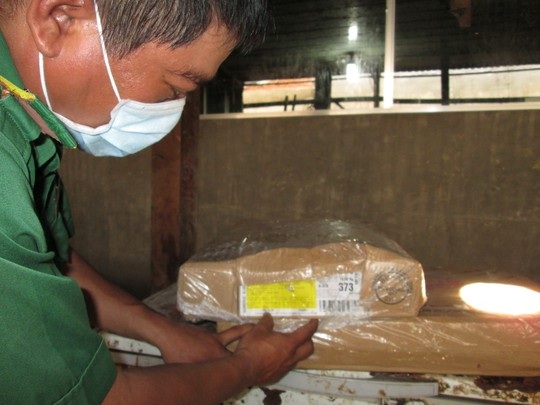 Thịt hết “đát” chạy đi đâu? - 1 Cán bộ QLTT kiểm tra hạn sử dụng của một lô thịt gà Mỹ