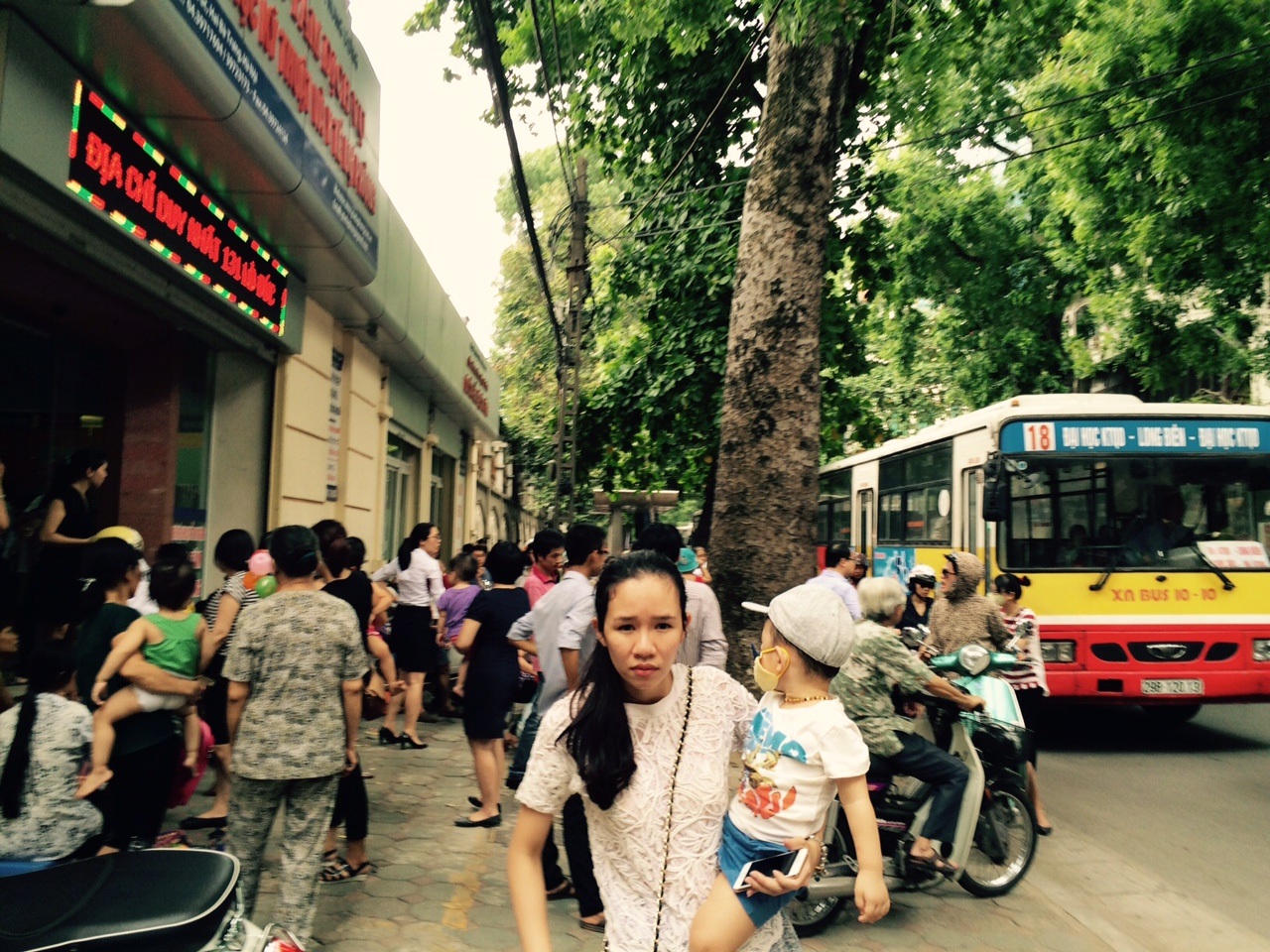 Nhiều cặp vợ chồng phải xin nghỉ làm để đưa con tới xếp hàng lấy số thứ tự.