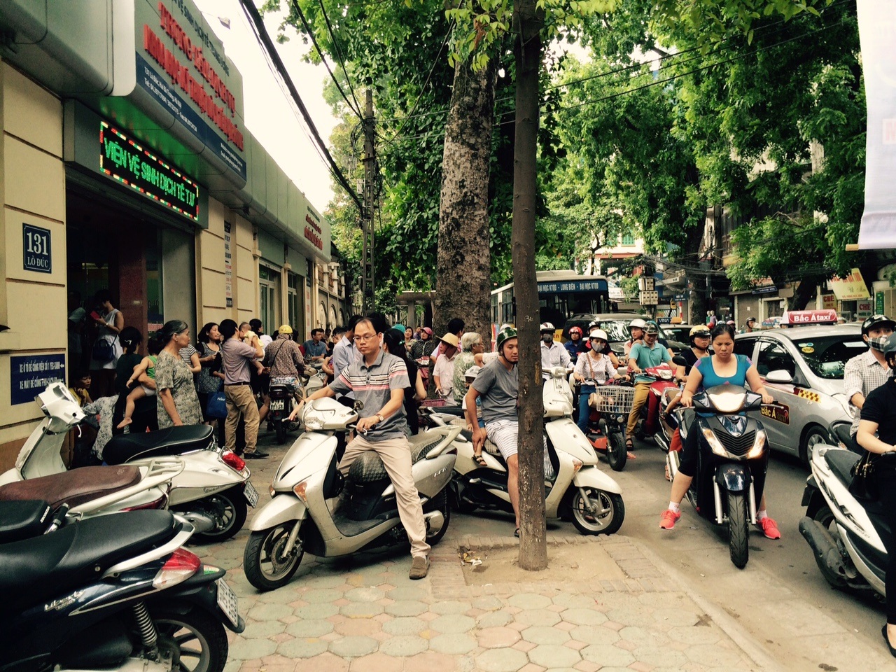 Nhiều cặp vợ chồng phải xin nghỉ làm để đưa con tới xếp hàng lấy số thứ tự.