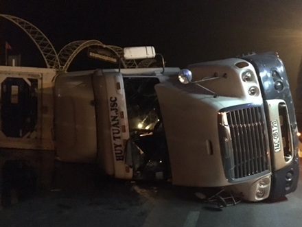 
Ôm cua qua vòng xuyến trước cổng Khu du lịch Tuần Châu, chiếc container chở hàng nặng bị lật nghiêng giữa đường.
