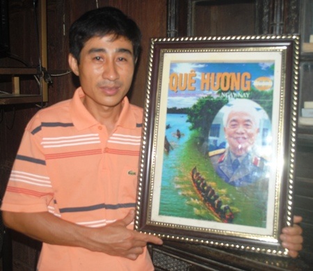 Anh Phạm Xuân Hóa rưng rưng ôm lấy bức hình của Đại tướng với quê hương Lệ Thủy
