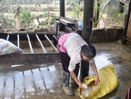 Bà Liến đau đớn nhìn số lúa, gạo bị ướt sũng trong nước