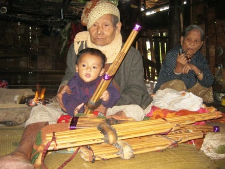 Đứa cháu nội, niềm vui tuổi già của cụ mới tròn 6 tháng tuổi cũng bắt chước cụ mân mê khèn bè