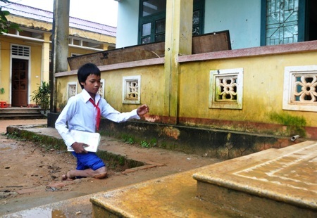 Em Hồ Văn Đào bước đến lớp trên đôi chân tật nguyền.