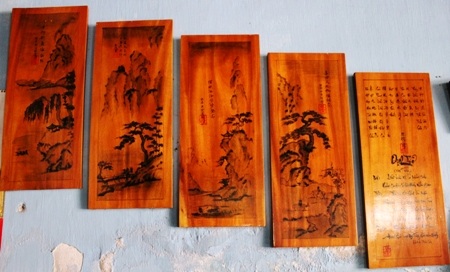 Một bài thơ do người khách từ TP Hồ Chí Minh nhờ ông dịch và viết trên gỗ