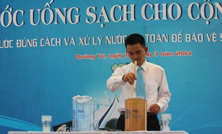 Cán bộ tham gia chương trình hướng dẫn cho bà con cách xử lý nước bằng túi lọc POW