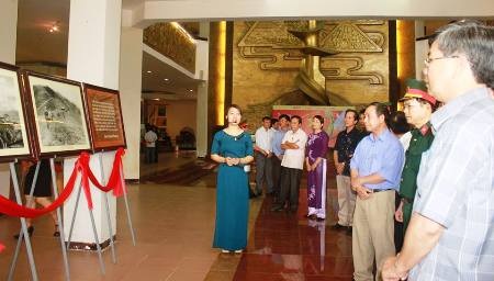 Gần 100 bức ảnh khơi dậy tinh thần chiến thắng Điện Biên Phủ - 1 Cán bộ tại Bảo tàng hướng dẫn khách tham quan