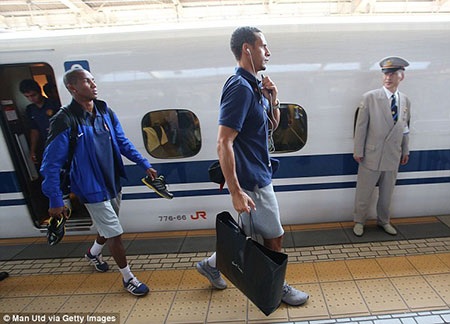 Ferdinand và Young, tiền vệ của MU đường như đang thiếu một chiếc túi khi phải cầm giày bằng tay