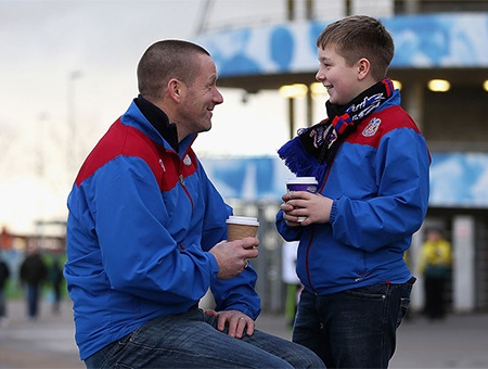 Hai người hâm mộ của đội khách đến sớm và chờ sân đấu mở cửa