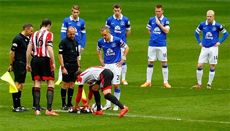 Tiền đạo Bornini đặt vòng hoa vào điểm giữa sân trước khi hai đội thể hiện phút mặc niệm