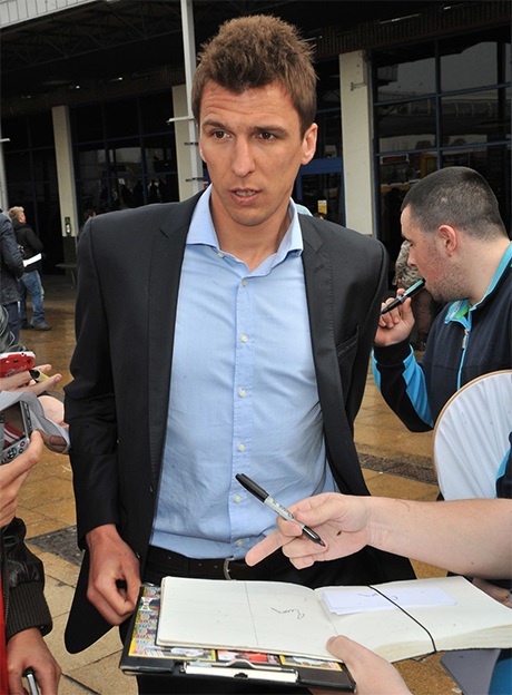 Một người hâm hộ chìa sẵn quyển sổ chờ tiền đạo Mario Mandžukić kí tặng