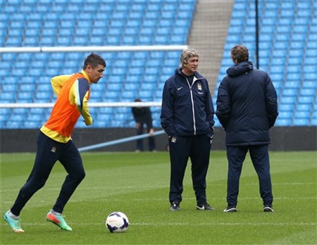 Pellegrini trao đổi với trợ lý trong khi các học trò tập luyện