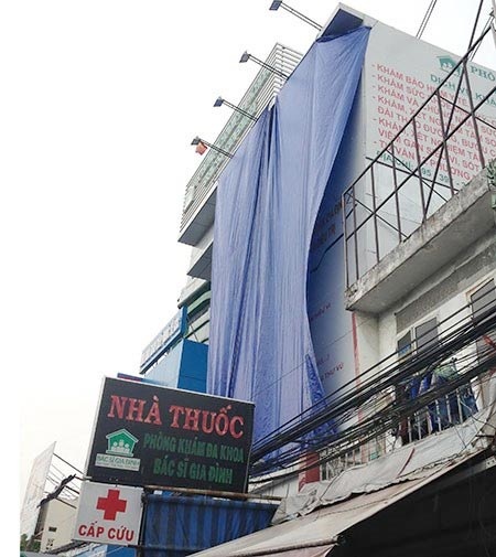 Phòng khám tư ‘núp bóng’ bệnh viện công? - 2 Bảng quảng cáo được che
lại sau khi vụ việc được phản ánh lên Sở Y tế TP. Ảnh: TÙNG SƠN
