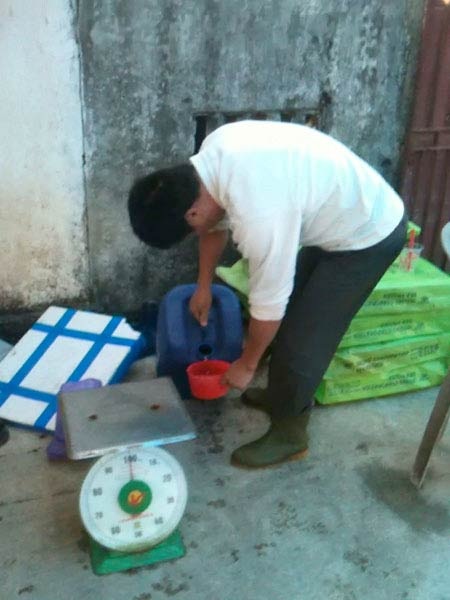 Ông Duyệt rót ôxy già từ can ra.