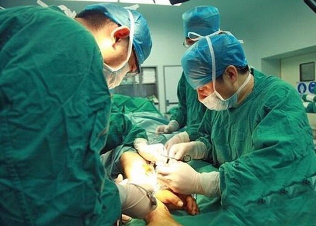 Trung Quốc: Phẫu thuật ghép bàn tay đứt lìa vào chân để cứu tay - 2 Các bác sỹ đang thực hiện ca phẫu thuật. (Nguồn: Daily Mail)