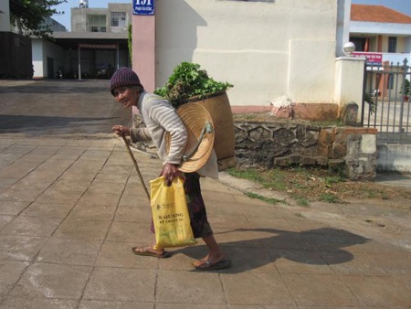 Hàng ngày, cụ bà này phải đeo gùi rau đầy ắp đi khắp phố núi để bán rau.
