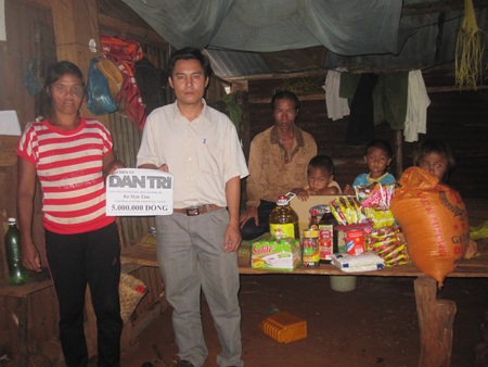 Đại diện chính quyền địa phương thay mặt bạn đọc trao quà cho gia đình chị Tăm