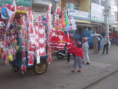 Một em bé đòi mẹ mua bộ quần áo ông già Noel (Ảnh: Thiên Thư)