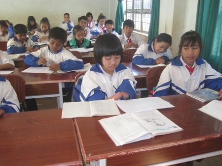 Em Blaih (tóc ngắn, ngồi đầu) đang ngồi vẽ trong giờ học.