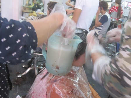 Đông khách đến mức thợ phải xả tóc ngay tại chỗ bằng ca nước