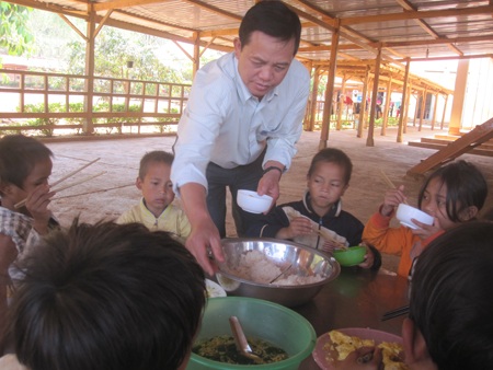 Thầy Tuấn bới cơm cho những em học sinh lớp 1 của trường