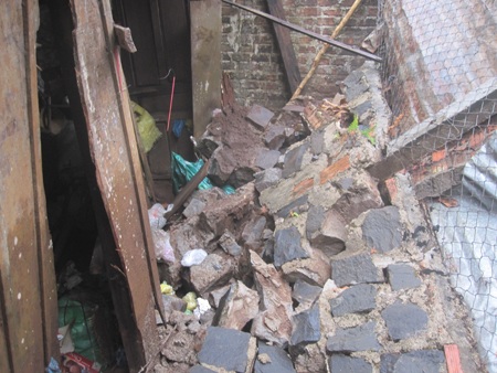 Mưa lớn từ các đường đổ về đoạn 44-50 Đống Đa khiến nước chảy như thác, làm đổ ập tường vào nhà dân