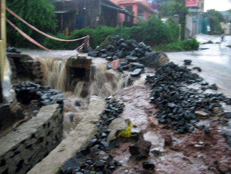 Mưa lớn, nước chảy xiết bóc luôn cả mặt đường