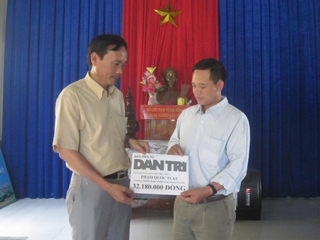 Thầy Hải (bên trái)- Trưởng phòng GD huyện Kbang thay mặt bạn đọc trao quà cho thầy Tuấn