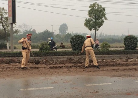 Hà Nội: CSGT mượn xẻng dọn đất trên đường - 1 Ngay khi phát hiện, tổ công tác CSGT đội 9 đã mượn xẻng tiến hành dọn bùn đất trên đường